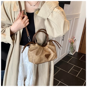 Detail of ruched vintage cloud bag in dark khaki with a deep brown cylindrical handle