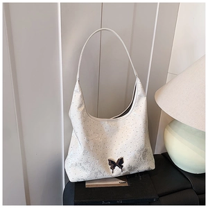 Detail der weißen Jacquard-Hobo-Tasche mit schwarzer Schmetterlings-Metallschnalle