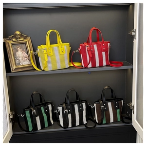 Détail de sacs seaux en maille tissée colorée avec motifs rayés et poignées en cuir