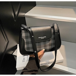 Detail of checkered pattern and leather trim on women crossbody bag with adjustable strap