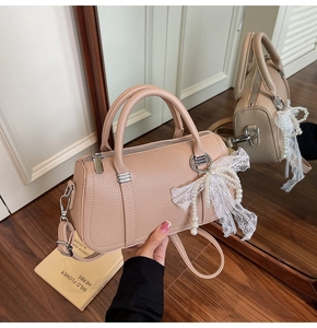 Detail of lychee pattern leather bag with pearl lace bow charm and silver hardware