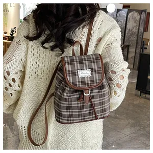 Retro plaid mini backpack with leather straps shown on model in a cozy interior setting