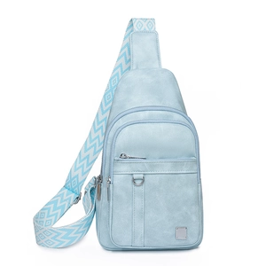 Detail view of light blue crossbody chest bag with geometric wave pattern strap