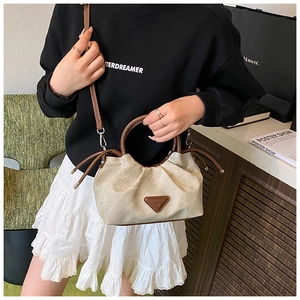 Detailed view of the pleated dumpling bag featuring a triangular logo and brown leather trim