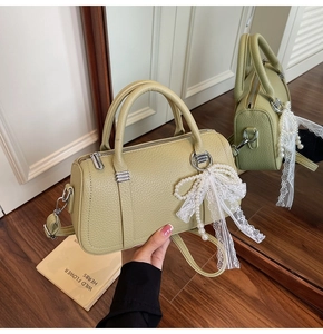 Detailed texture of green lychee leather bag with pearl lace bow and silver hardware