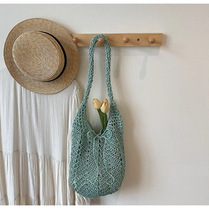 Detail of mint green hollow crochet tote bag with summer aesthetic and knit texture