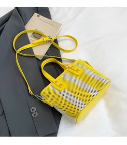 Détail du sac cabas en maille rayée jaune et blanc avec bordure en cuir et clous