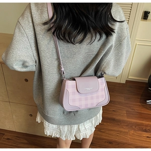 Detail of light purple plaid crossbody bag with adjustable strap worn by a person