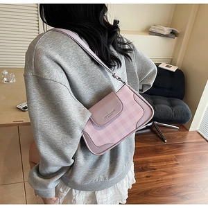 Close-up of lavender plaid patterns and leather flap detail on the shoulder bag