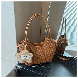 Détail du sac cabas marron tissé avec breloque étoile en peluche et fine bandoulière