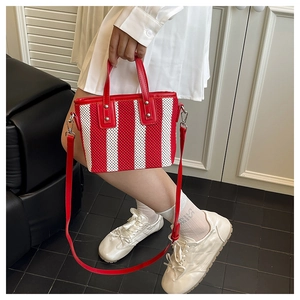 Détail du sac cabas en maille rayée rouge et blanc avec bandoulière en cuir amovible