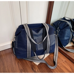 Detail of large denim tote bag featuring patchwork design and detachable shoulder strap