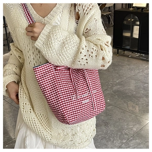 Detailed close-up of red and white gingham canvas tote bag with Rose and More text design