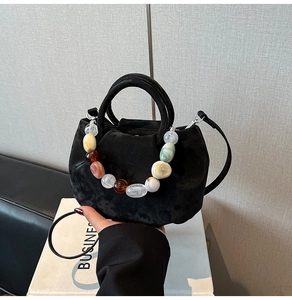 Détail du sac seau en velours noir avec perles en résine colorées et fine bandoulière