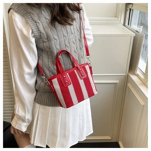 Détail de la texture en maille rayée rouge et blanc et de la bandoulière en cuir rouge