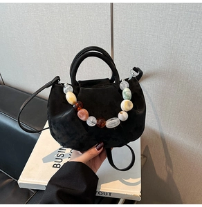 Détail d'un sac seau en velours noir avec perles en résine colorées et bandoulière