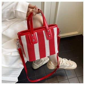 Mannequin portant un sac cabas tissé rouge et blanc avec bandoulière réglable