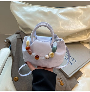 Détail du sac seau lilas avec chaîne en perles colorées et fine bandoulière réglable