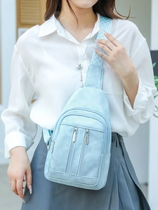 Light blue retro crossbody bag with geometric shoulder strap shown on a model