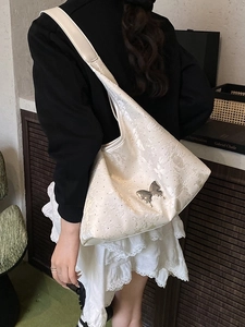 Schicke beige Schultertasche mit Blumenstickerei und silbernem Schmetterling am Gurt