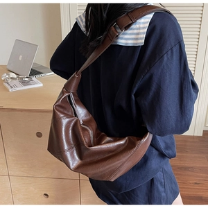 Macro shot of dark brown oil wax leather croissant bag with wide shoulder strap