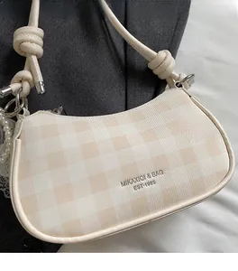 Détail du sac à bandoulière beige à carreaux avec bandoulière nouée et perle