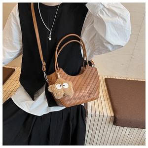 Détail du sac cabas tressé marron en PU avec poignées rondes et breloque étoile en peluche