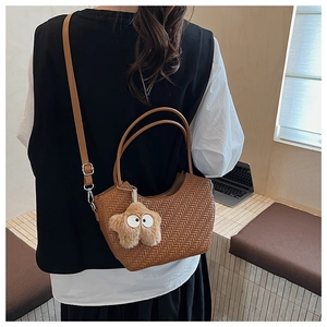 Détail de la texture tressée du sac cabas marron avec pendentif étoile et bandoulière
