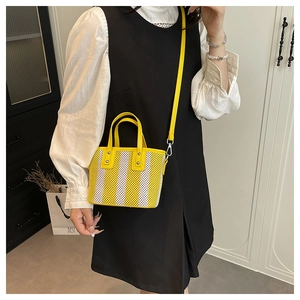 Détail du mini cabas tissé à rayures jaunes et blanches avec bandoulière et poignées