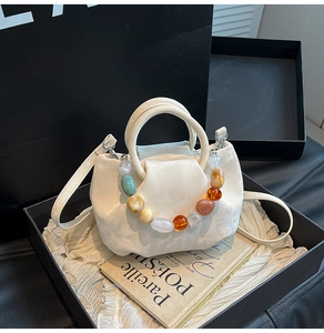 Détail du sac seau plissé blanc avec sa poignée unique en perles de marbre