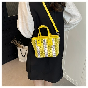 Détail du mini sac cabas en maille tissée à rayures jaunes et blanches avec bandoulière