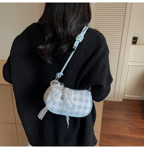 Détail du sac bandoulière croissant à carreaux bleus et blancs avec nœud en perles