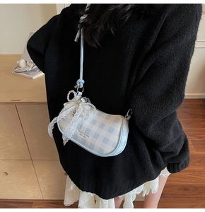 Détail du sac sous le bras à carreaux bleu clair avec nœud en dentelle et perle