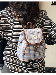 Light blue plaid canvas backpack with leather trim and buckle closure for women