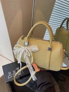 Lime green leather pillow bag with lace bow and pearl chain in a chic handheld style