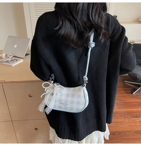 Détail du sac demi-lune à carreaux bleu et blanc avec nœud en dentelle et perles