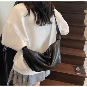 Detail of black pleated PU leather crescent bag with stylish knot handle and large capacity