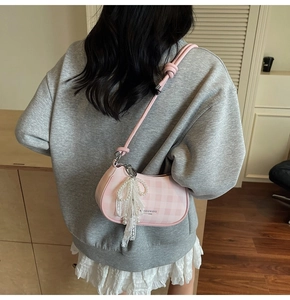 Détail du sac à carreaux rose avec chaîne en perles et nœud en dentelle chic