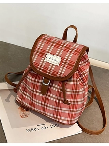Red plaid canvas backpack with brown leather trim and drawstring closure for women