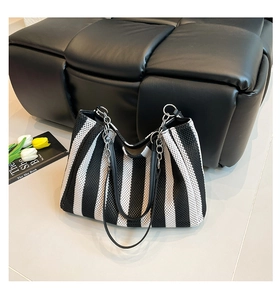 Detailed close-up of the woven texture and black leather handles on stripe tote bag