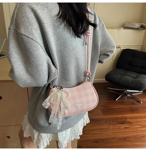 Détail du sac à bandoulière à carreaux roses avec nœud en dentelle et perles de luxe