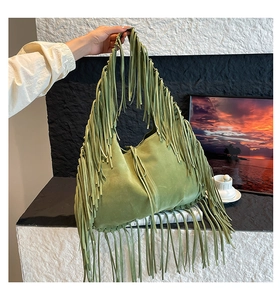 Detail shot of vintage green suede tote bag with stylish long fringes and shoulder strap