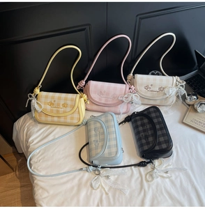 Flat lay of checkered crossbody bags in yellow, pink, blue, and black with pearl charms