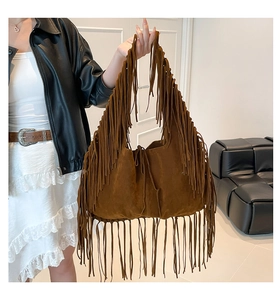 Detailed close-up of dark brown suede fringe tote bag featuring bohemian tassel accents