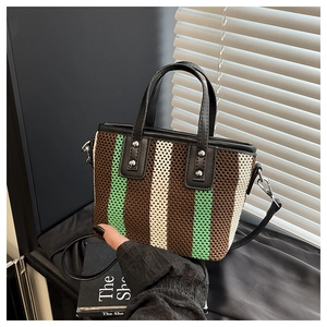 Gros plan du sac tissé à rayures avec finitions en cuir et détails de rivets en métal