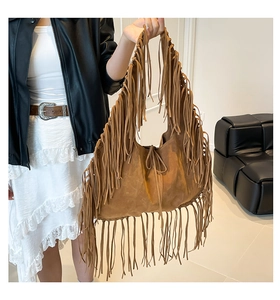 Detail of large brown suede hobo bag with long fringes and bohemian drawstring closure