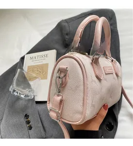 Detail of pink Boston bag with lychee texture and silver hardware in lifestyle setting