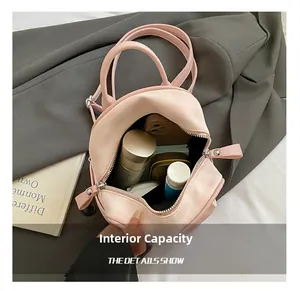 Internal capacity of pink mini backpack showing phone, lipstick and cosmetics inside