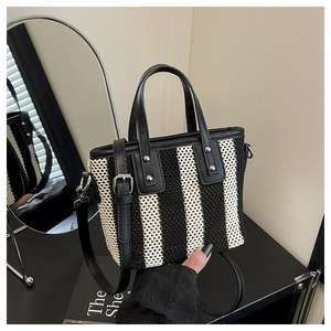 Détail du sac seau tissé à rayures noires et blanches avec poignées en cuir élégantes