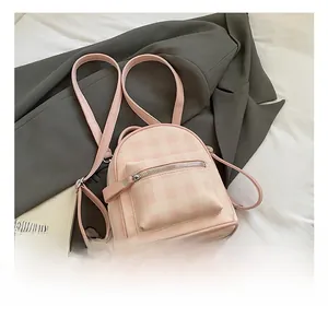 Detail of pink plaid pattern and front zipper pocket on a compact stylish backpack